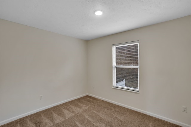 carpeted empty room with a textured ceiling