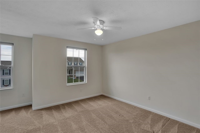 spare room featuring carpet flooring, ceiling fan, and a textured ceiling