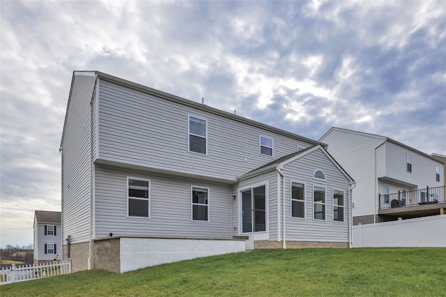 rear view of house featuring a lawn