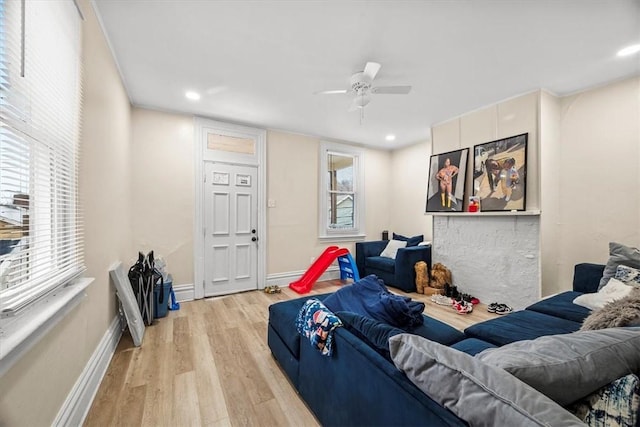 living room featuring ceiling fan, a healthy amount of sunlight, and light wood-type flooring