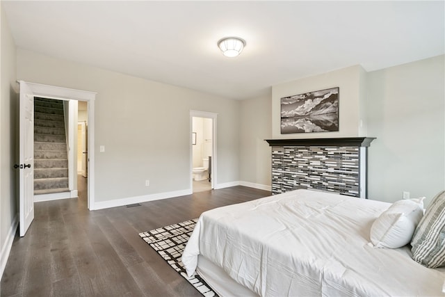 bedroom with ensuite bath and dark wood-type flooring