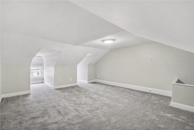 additional living space with carpet flooring and vaulted ceiling