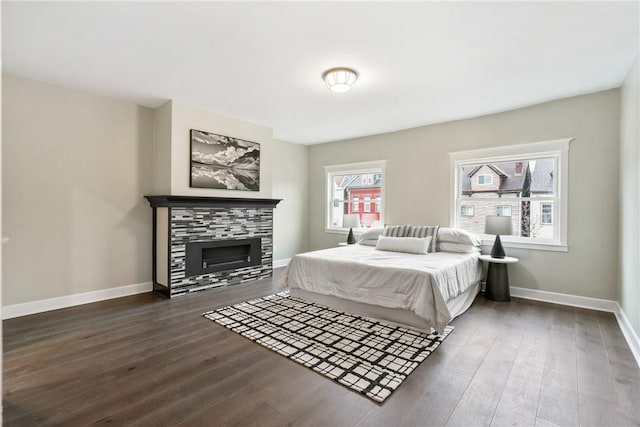 bedroom featuring dark hardwood / wood-style flooring and a tiled fireplace