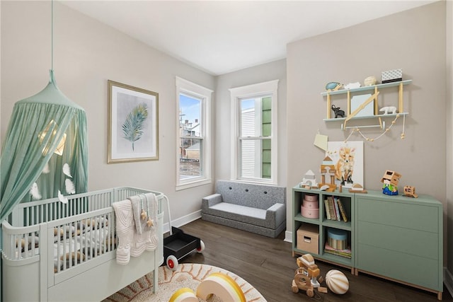 bedroom featuring dark hardwood / wood-style flooring and a crib