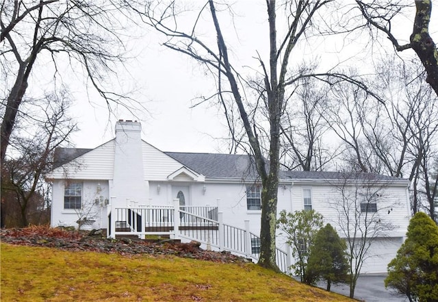 back of property with a lawn and a garage