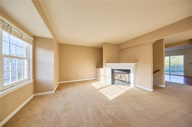 unfurnished living room with a healthy amount of sunlight and light colored carpet