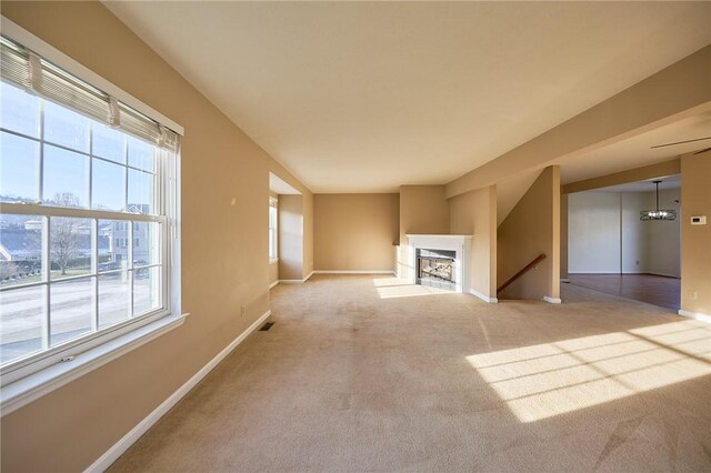 unfurnished living room with carpet flooring and plenty of natural light