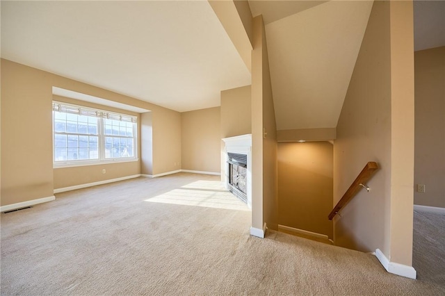 unfurnished living room featuring light colored carpet and lofted ceiling