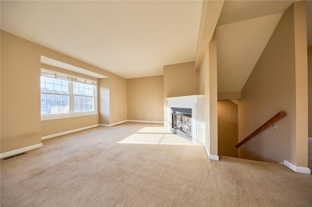 unfurnished living room featuring light colored carpet and vaulted ceiling