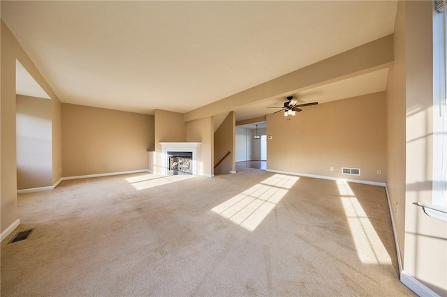 unfurnished living room with light colored carpet and ceiling fan