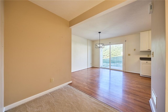 unfurnished dining area featuring hardwood / wood-style floors and an inviting chandelier