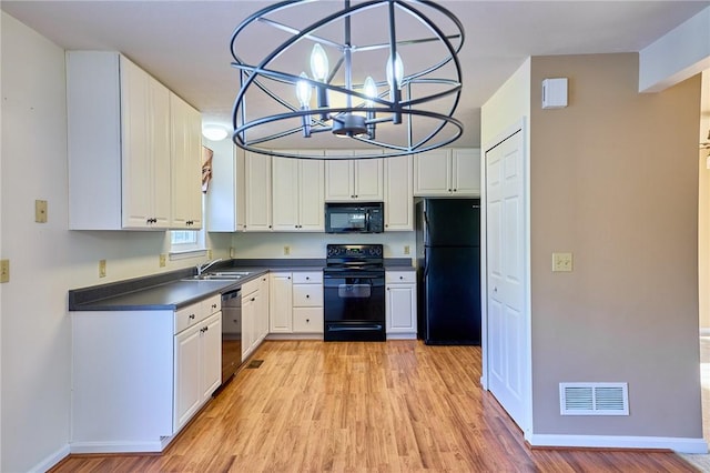 kitchen with sink, light hardwood / wood-style flooring, a chandelier, white cabinets, and black appliances