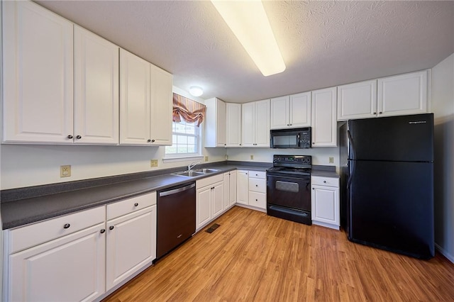 kitchen with white cabinetry, sink, light hardwood / wood-style flooring, a textured ceiling, and black appliances