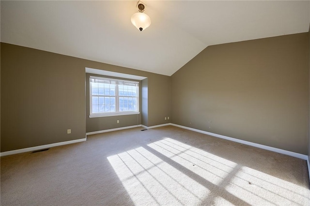 carpeted empty room featuring lofted ceiling