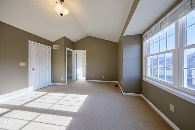 unfurnished bedroom with light carpet and vaulted ceiling