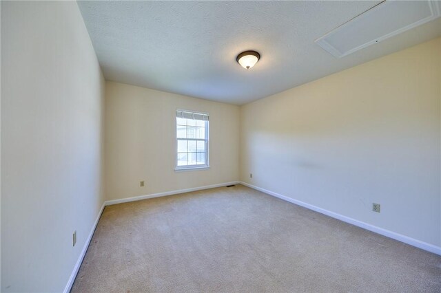 spare room with light carpet and a textured ceiling