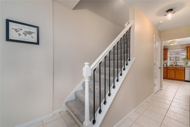 stairway featuring tile patterned flooring and sink