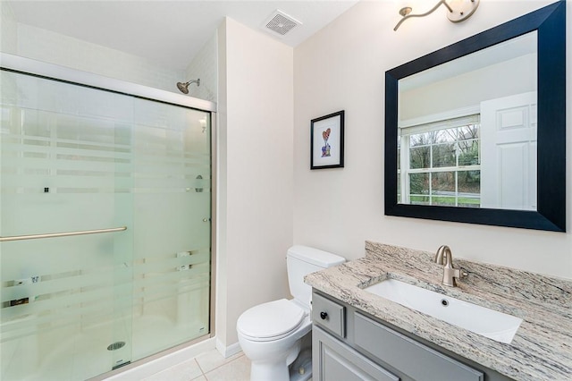 bathroom with toilet, vanity, tile patterned floors, and a shower with door