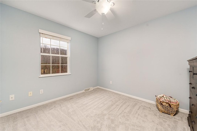 spare room with ceiling fan and light colored carpet