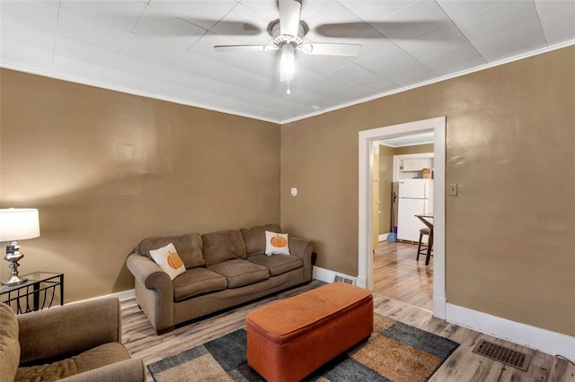 living room with ceiling fan, light hardwood / wood-style flooring, and ornamental molding