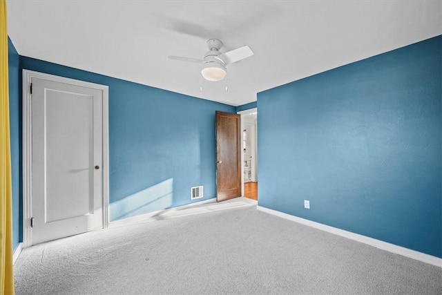 empty room featuring carpet flooring and ceiling fan