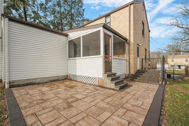 back of house featuring a sunroom and a patio