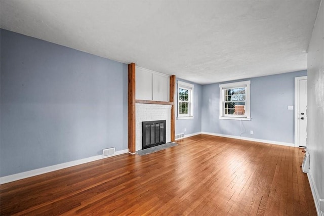 unfurnished living room featuring hardwood / wood-style floors and a fireplace