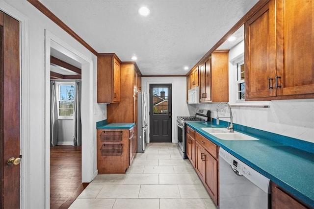 kitchen featuring plenty of natural light, light tile patterned flooring, stainless steel appliances, and sink