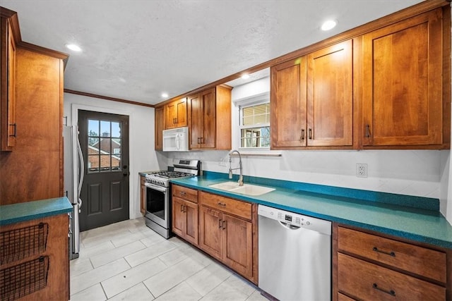 kitchen featuring sink, stainless steel appliances, and ornamental molding