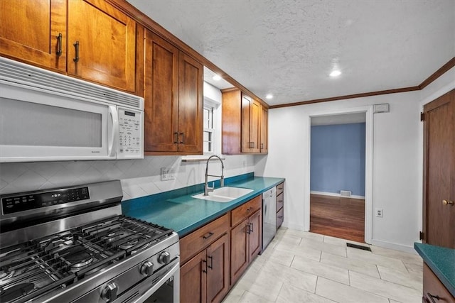 kitchen featuring sink, light tile patterned floors, ornamental molding, and appliances with stainless steel finishes