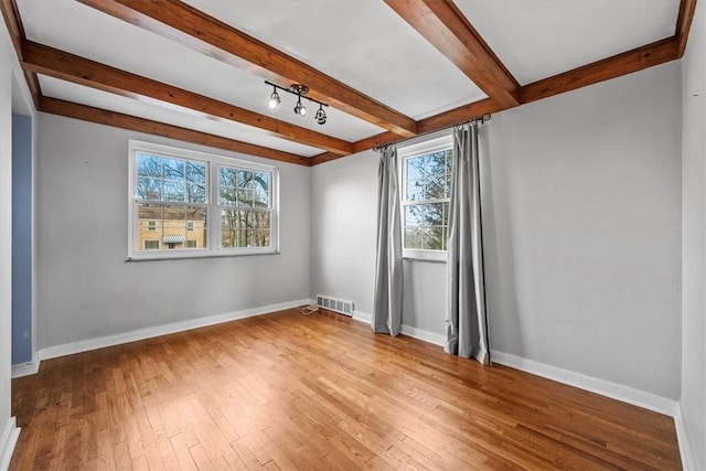 unfurnished room with beam ceiling and wood-type flooring