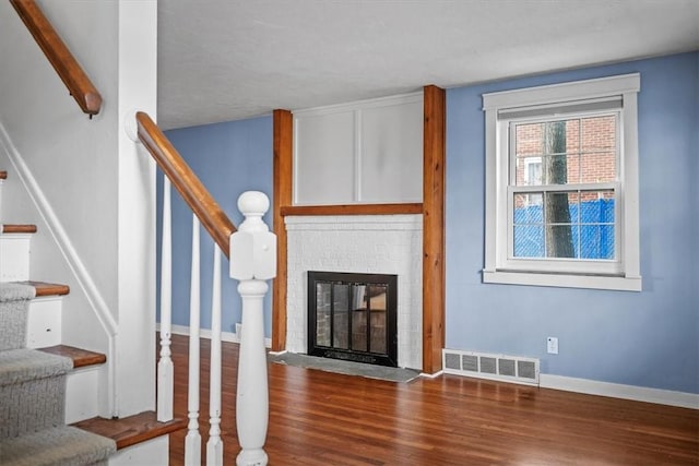 stairs featuring vaulted ceiling with beams, a fireplace, and hardwood / wood-style floors