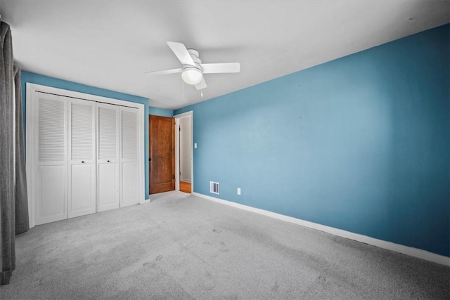 unfurnished bedroom with ceiling fan, a closet, and light colored carpet