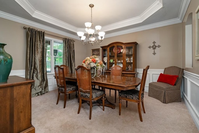 dining room with a tray ceiling, light carpet, and a notable chandelier