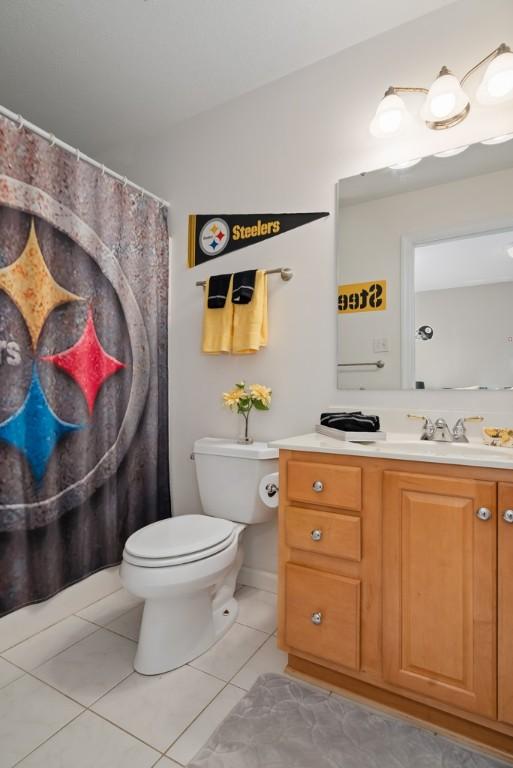 bathroom featuring tile patterned flooring, vanity, and toilet