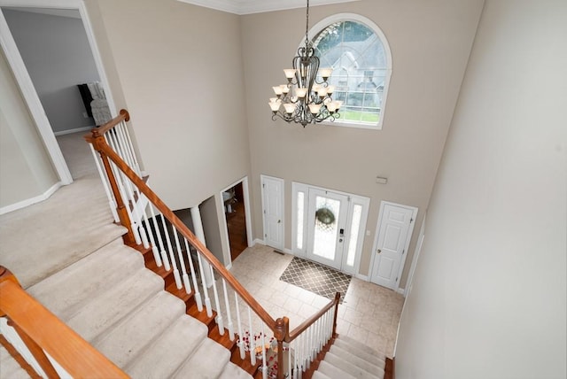 entrance foyer featuring crown molding, a chandelier, and a high ceiling