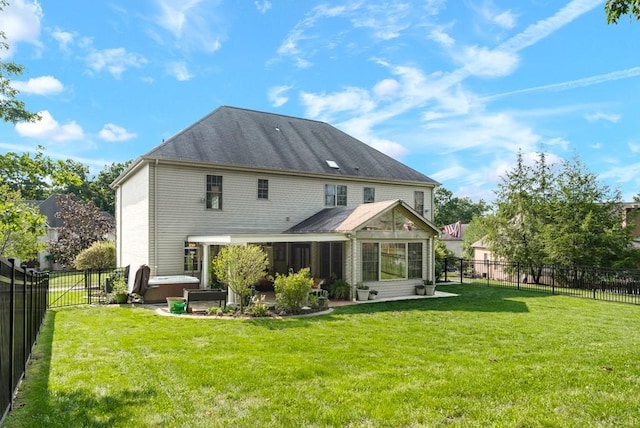 back of property with a yard and a hot tub