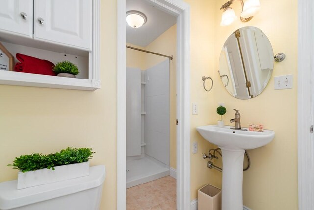 bathroom featuring a shower, sink, and toilet