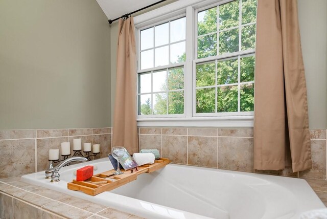 bathroom with a relaxing tiled tub