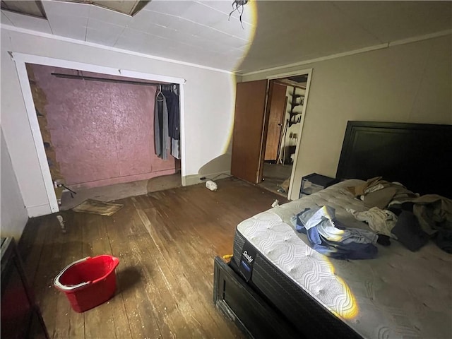 bedroom featuring a closet, ornamental molding, and hardwood / wood-style flooring
