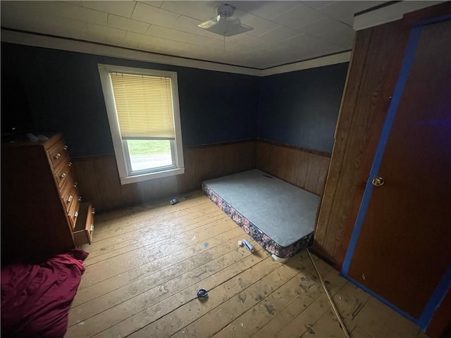 unfurnished bedroom featuring wood walls and light hardwood / wood-style flooring