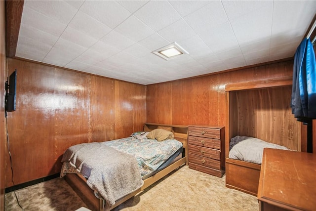 bedroom with carpet floors and wood walls