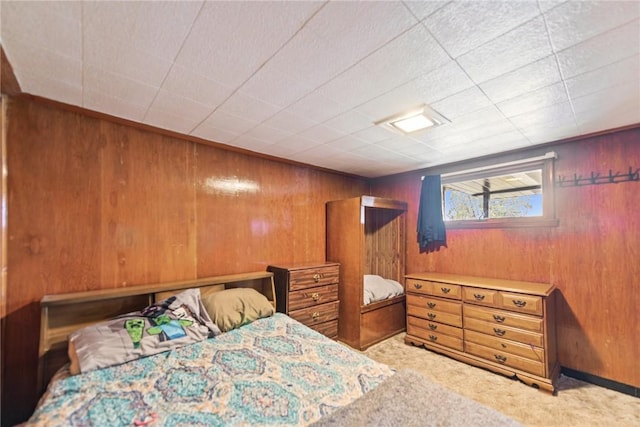 carpeted bedroom featuring wood walls