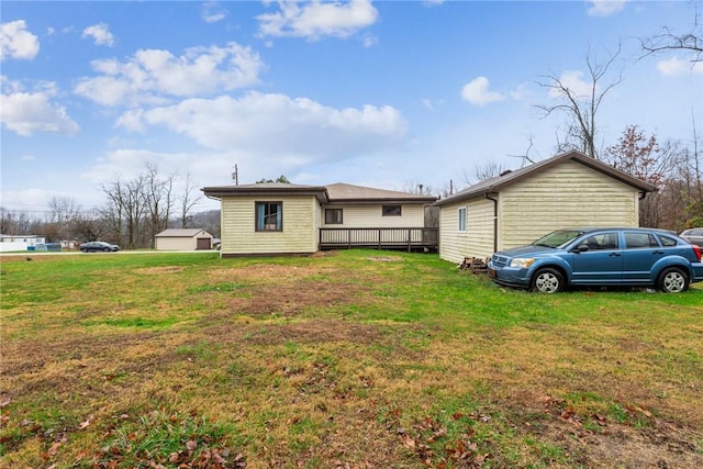 back of house featuring a deck and a lawn