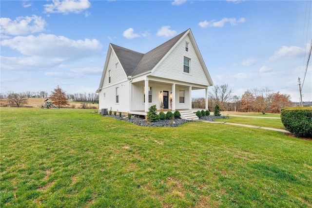 view of front of house featuring cooling unit, covered porch, and a front yard