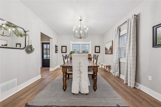 dining area with hardwood / wood-style flooring and a chandelier