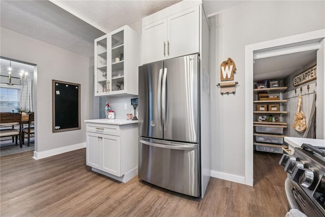 kitchen featuring white cabinetry, light hardwood / wood-style flooring, stainless steel appliances, and a textured ceiling