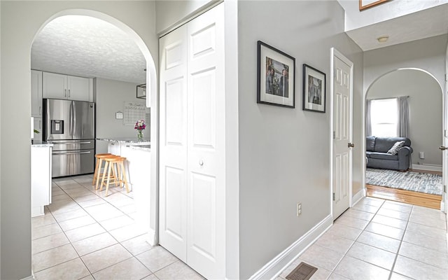 corridor featuring a textured ceiling and light hardwood / wood-style flooring