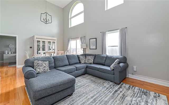 living room with a notable chandelier, a high ceiling, and hardwood / wood-style flooring