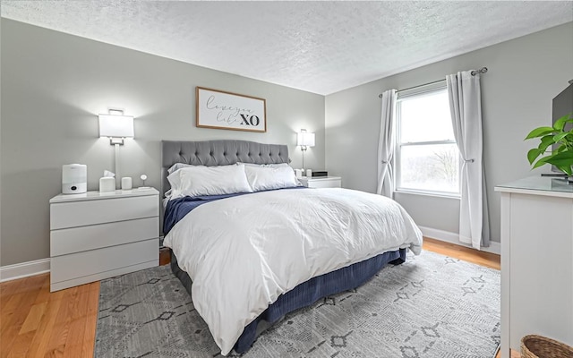 bedroom featuring light hardwood / wood-style floors and a textured ceiling